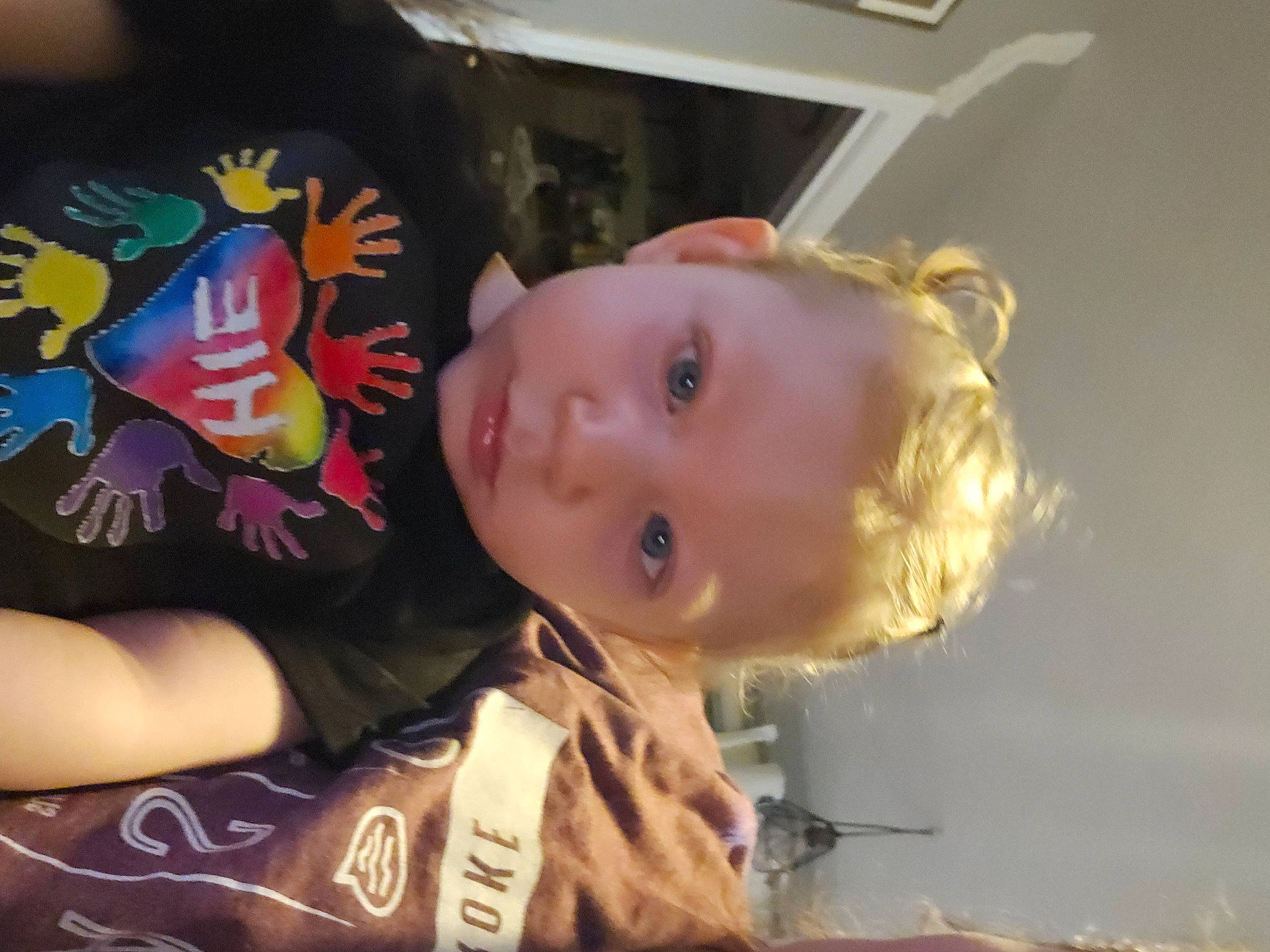 Willa is registered to the contest to win money with this photo: baby, baby_toddler_clothing, carmine, cheek, child, ear, elbow, eye, flooring, fun, happy, iris, mouth, nose, person, room, sitting, sleeve, t_shirt, toddler