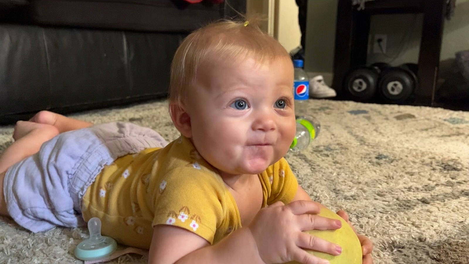 Eva is registered to the contest to win money with this photo: baby, baby_products, baby_toddler_clothing, cheek, child, eye, face, flooring, foot, fun, grass, happy, human_leg, iris, person, play, sitting, skin, smile, thumb