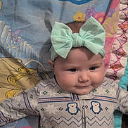 Willow joined the competition — help win amazing prizes! baby, infant, child, headband, bow, pajamas, penguin_pattern, blanket, bed, pillow, smile, cheeks, portrait, lying_down, cute, cozy, patterned_fabric, sleepwear, indoor, closeup