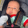 baby, infant, car_seat, seatbelt, blanket, football_pattern, star_pattern, mittens, clothing, child, face, head, person, sitting, closeup, cute, indoors, safety, transport, newborn