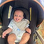 baby, child, car_seat, stroller, outdoor, playful, tongue_out, bib, happy, infant, person, seat, clothing, sunlight, legs, hands, head, smile, cute, expression