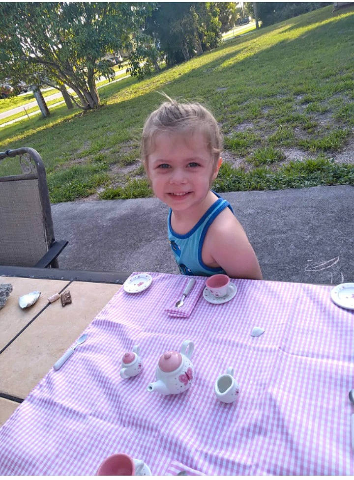 Luna Rae is registered to the contest to win money with this photo: chair, child, electric_blue, flooring, food, fun, grass, green, joy, lawn, leisure, pattern, people, person, plant, recreation, smile, table, tableware, toddler