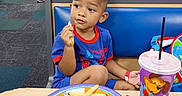 Elijah joined the competition — help win amazing prizes! blue_outfit, boy, casual_clothing, child, colorful, cup, curious, drink, family, fast_food, food, fries, indoor, people, pizza, plate, restaurant, sitting, spiderman, table