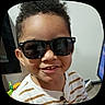 Elijah is registered to the contest to win money with this photo: child, smiling, sunglasses, indoor, striped_shirt, face, person, cute, happy, portrait, young, hair, fashion, eyewear, casual, home, childhood, playful, cool, kid