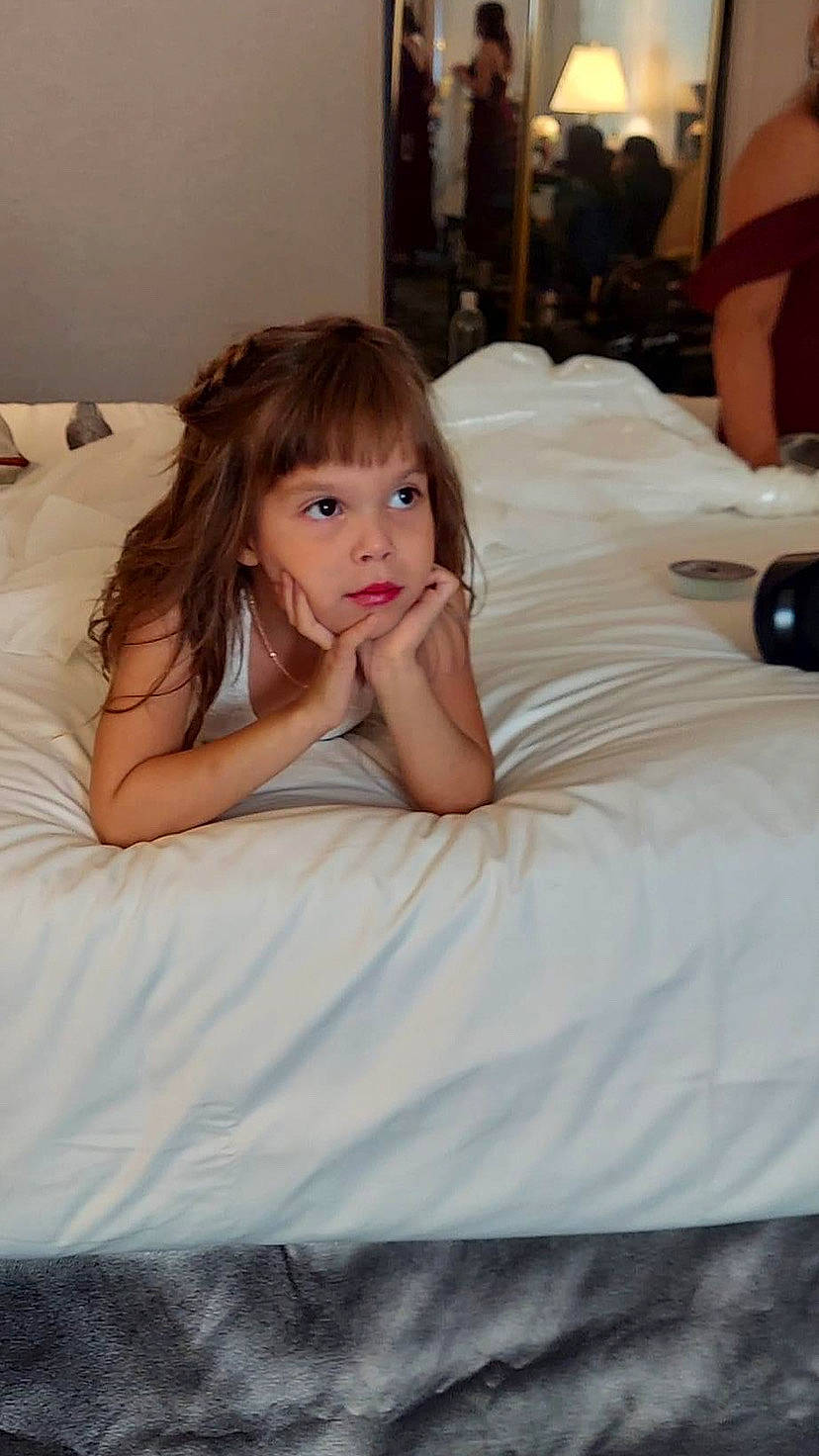 Maddison is registered to the contest to win money with this photo: bed, bedding, bedroom, black_hair, camera, comfort, couch, event, finger, flash_photography, floor, flooring, gown, happy, human_leg, linens, long_hair, person, shoulder, skin