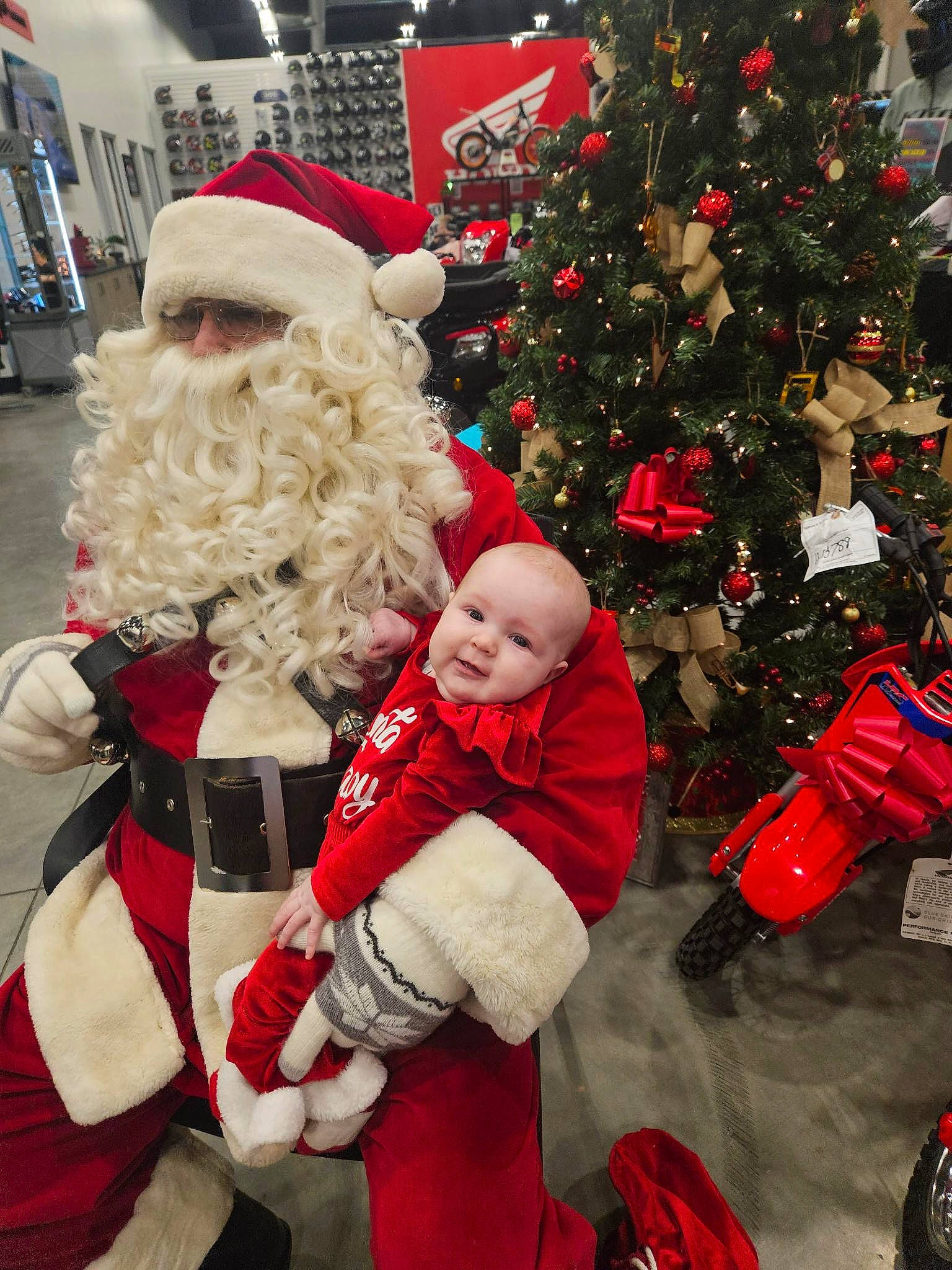 Aida is registered to the contest to win money with this photo: beard, christmas, christmas_decoration, christmas_eve, christmas_ornament, christmas_tree, event, fictional_character, fun, happy, hat, holiday, holiday_ornament, lap, person, plant, red, santa_claus, standing, tree