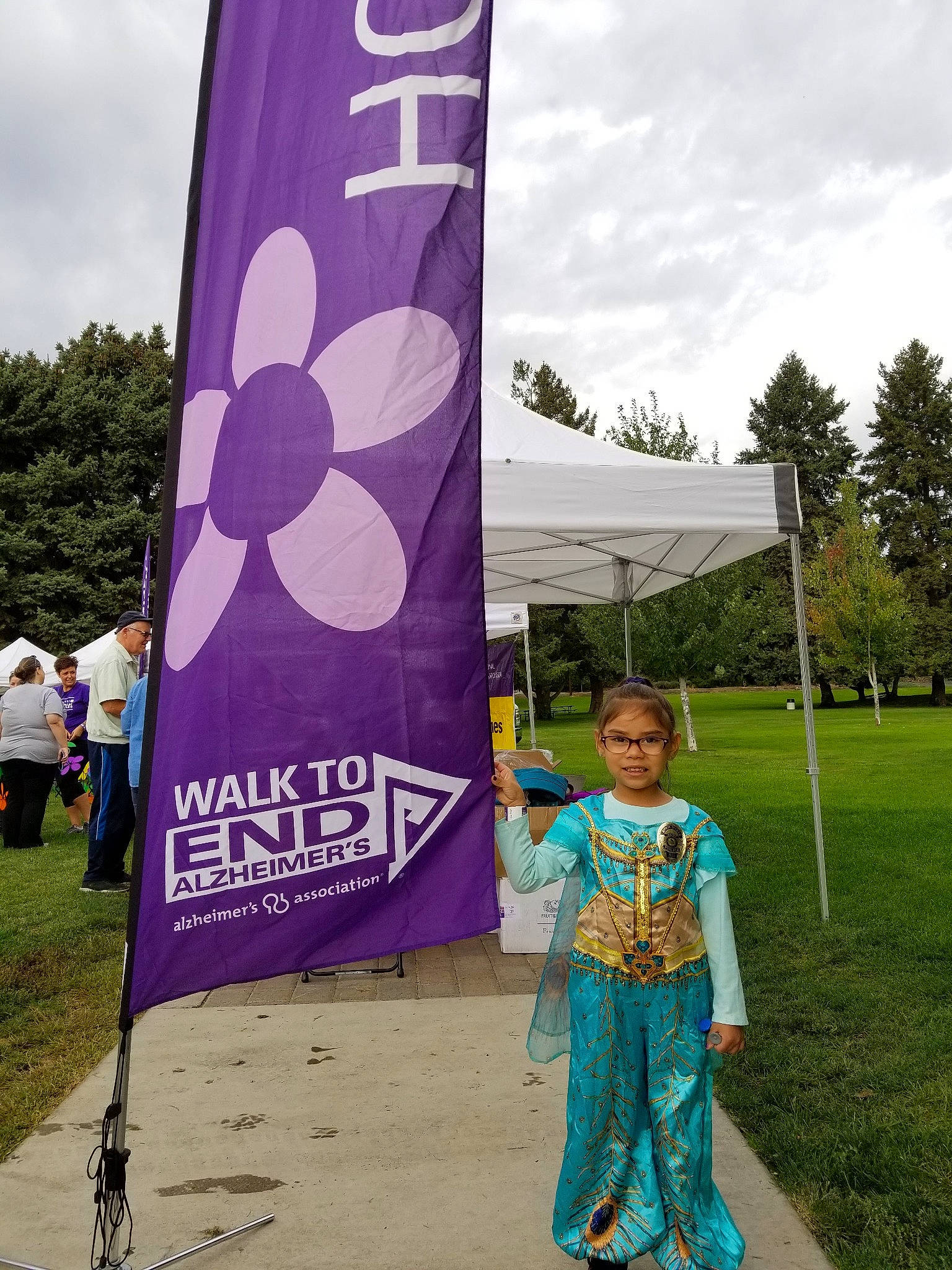 Nariah is registered to the contest to win money with this photo: advertising, banner, child, flag, fun, games, headwear, joy, person, plant, purple, recreation, tree, vacation, world