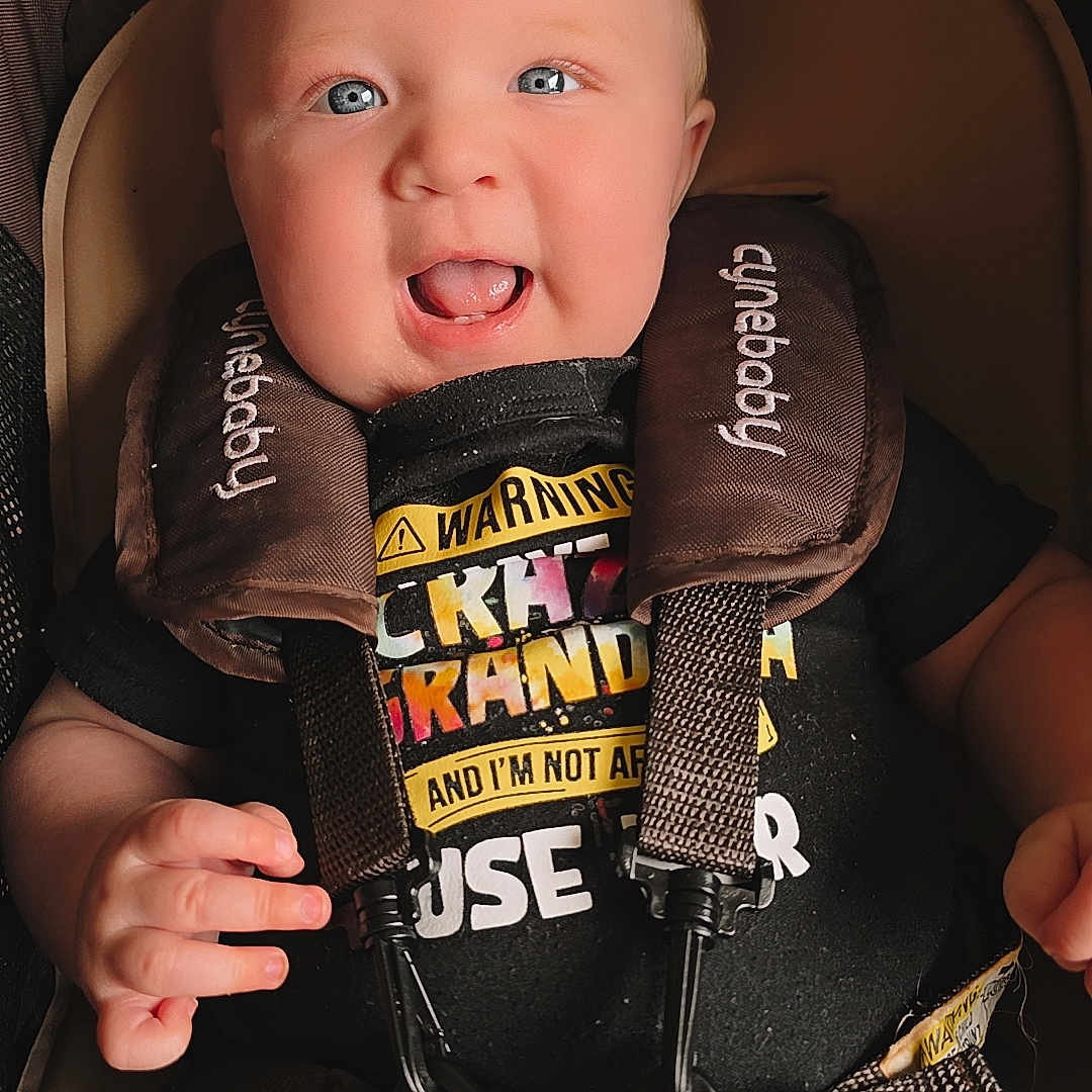 Dawson joined the competition — help win amazing prizes! accessories, baby, bodypart, car, car_interior, carseat, clothing, face, finger, gun, hand, head, lifejacket, person, photography, portrait, transportation, vehicle, vest, weapon