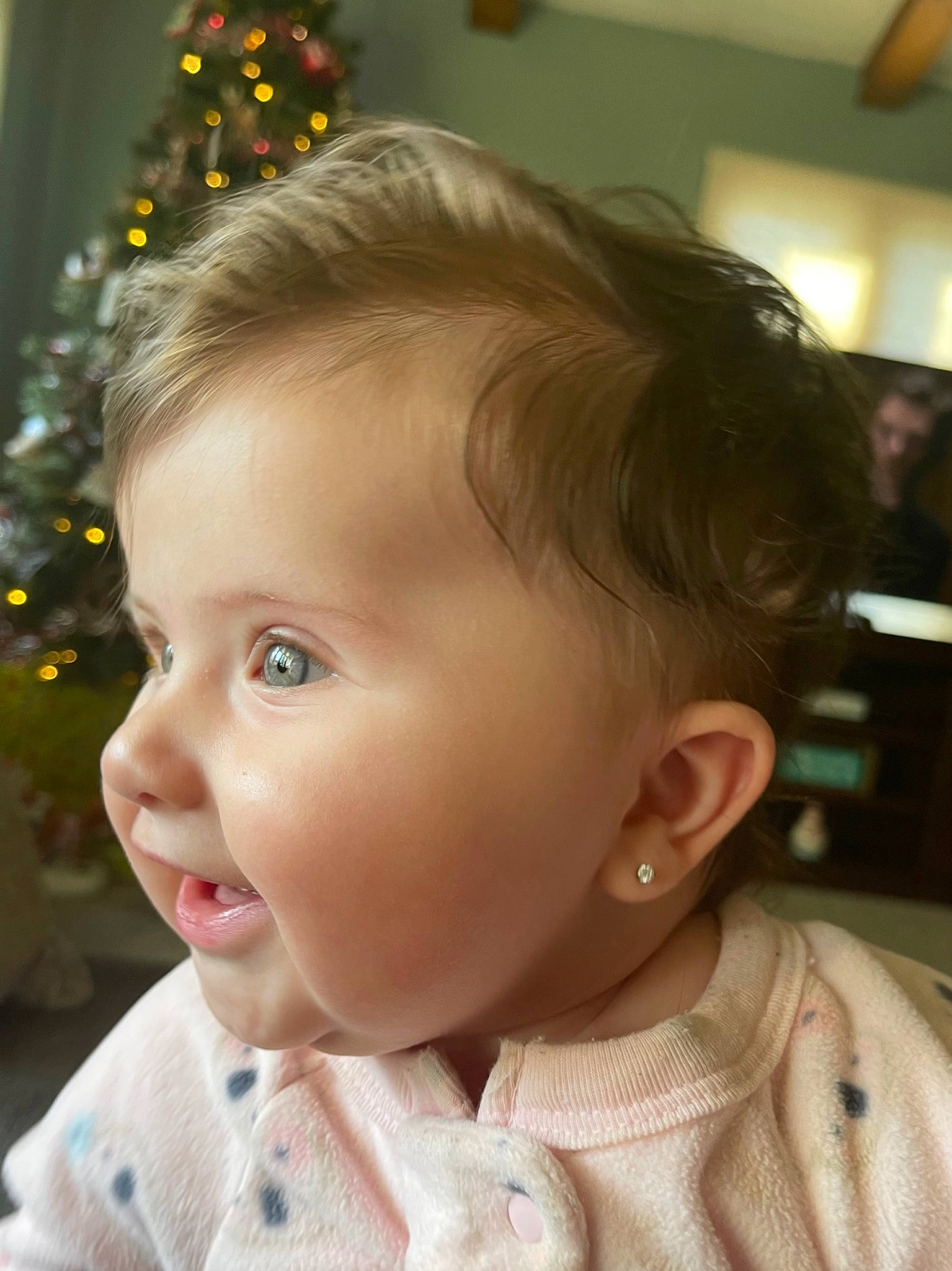 Evelyn is registered to the contest to win money with this photo: baby, baby_toddler_clothing, cheek, chin, christmas_tree, collar, dress_shirt, ear, eyebrow, eyelash, facial_expression, forehead, happy, head, iris, lip, nose, person, skin, sleeve