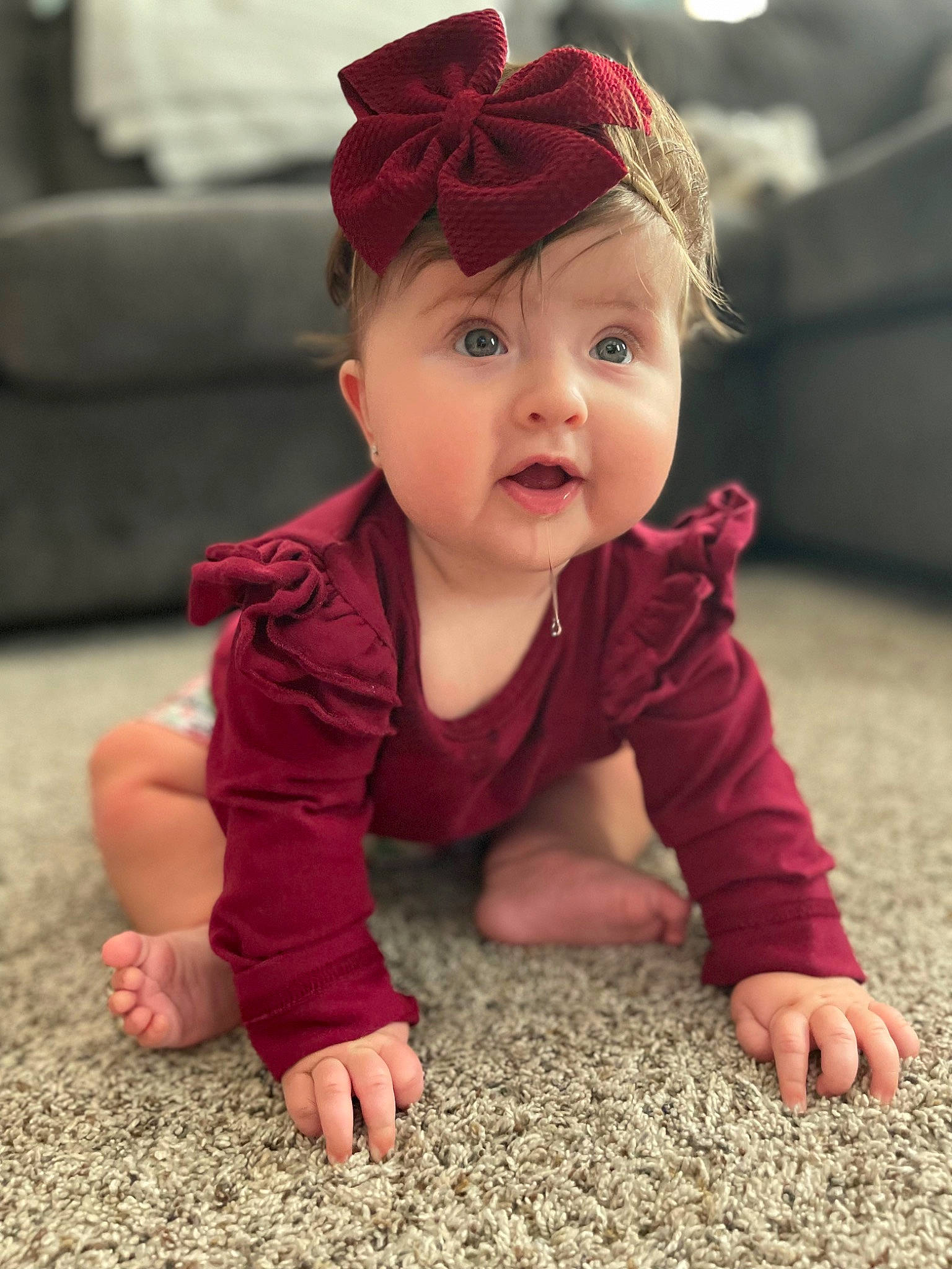 Evelyn is registered to the contest to win money with this photo: baby, baby_toddler_clothing, cheek, child, crawling, floor, flooring, fun, grass, happy, hardwood, headwear, iris, magenta, people, person, red, skin, sleeve, smile
