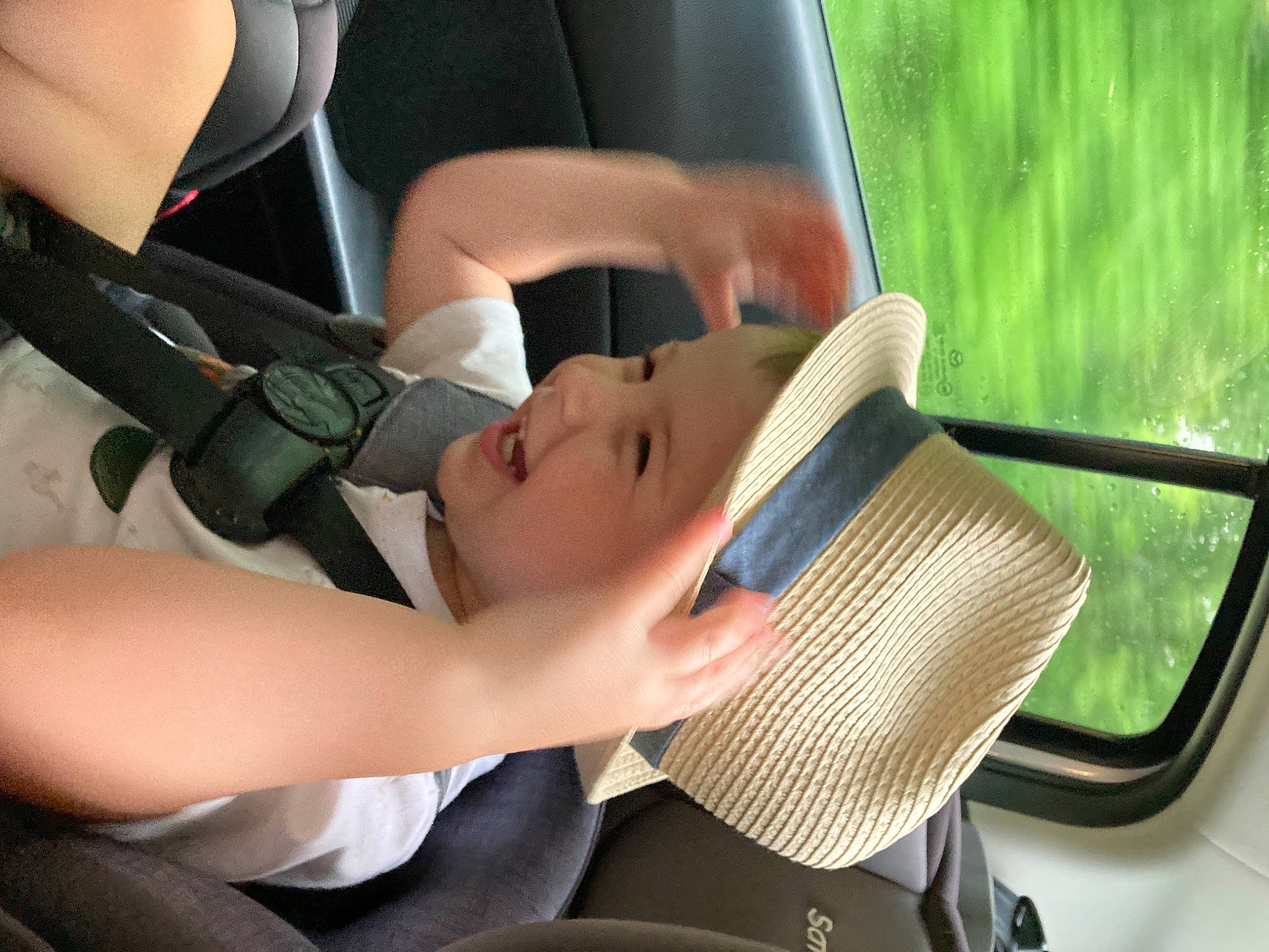 Canaan is registered to the contest to win money with this photo: auto_part, automotive_exterior, automotive_mirror, car_seat, child, fashion_accessory, grass, hand, happy, hat, headgear, headwear, leisure, mammal, person, rear_view_mirror, recreation, sun_hat, travel, vehicle_door