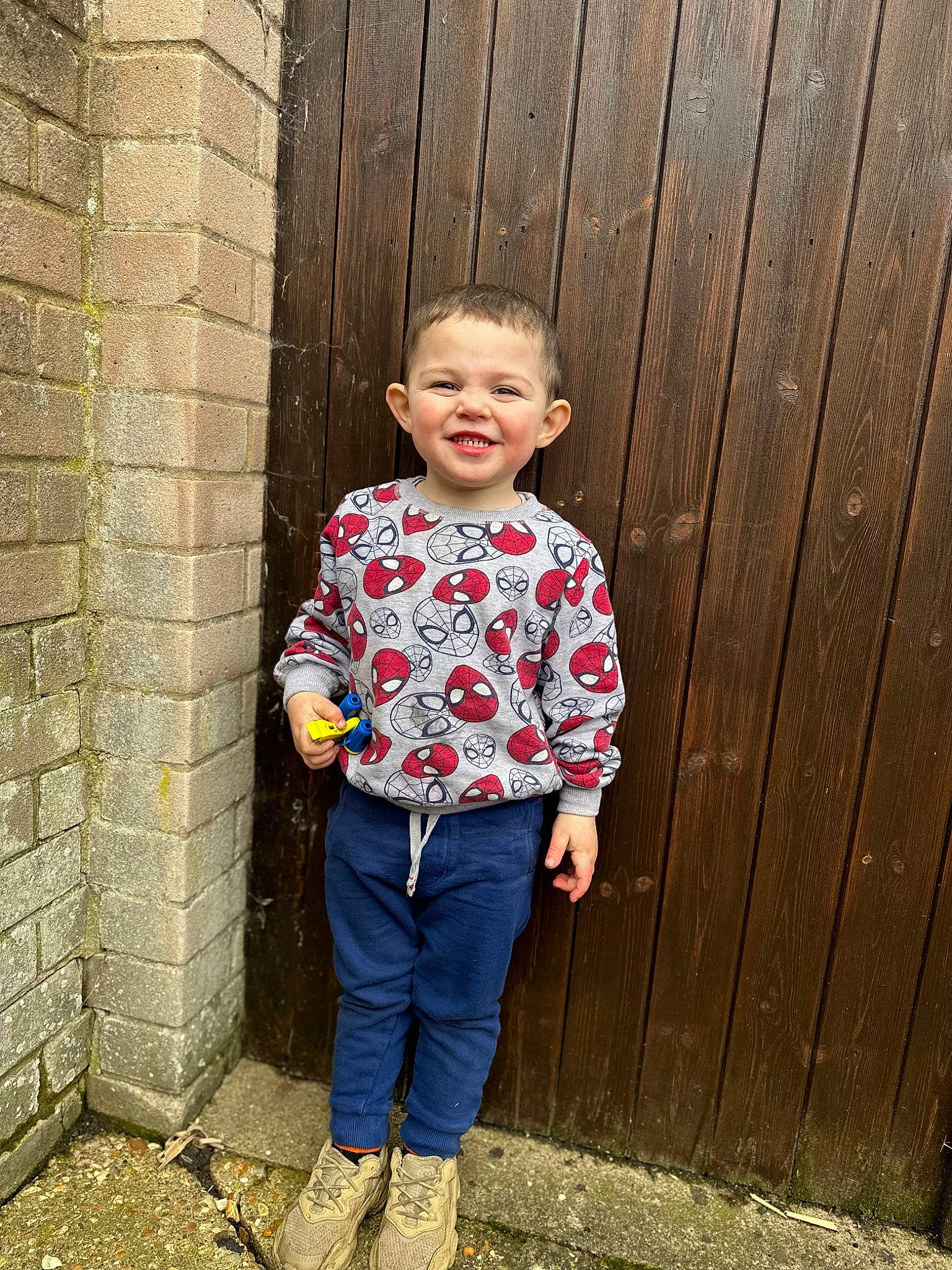 Logan joined the competition — help win amazing prizes! baby_toddler_clothing, brick, brickwork, child, denim, electric_blue, formal_wear, grass, happy, joy, magenta, pattern, person, plaid, sleeve, smile, standing, t_shirt, toddler, waist