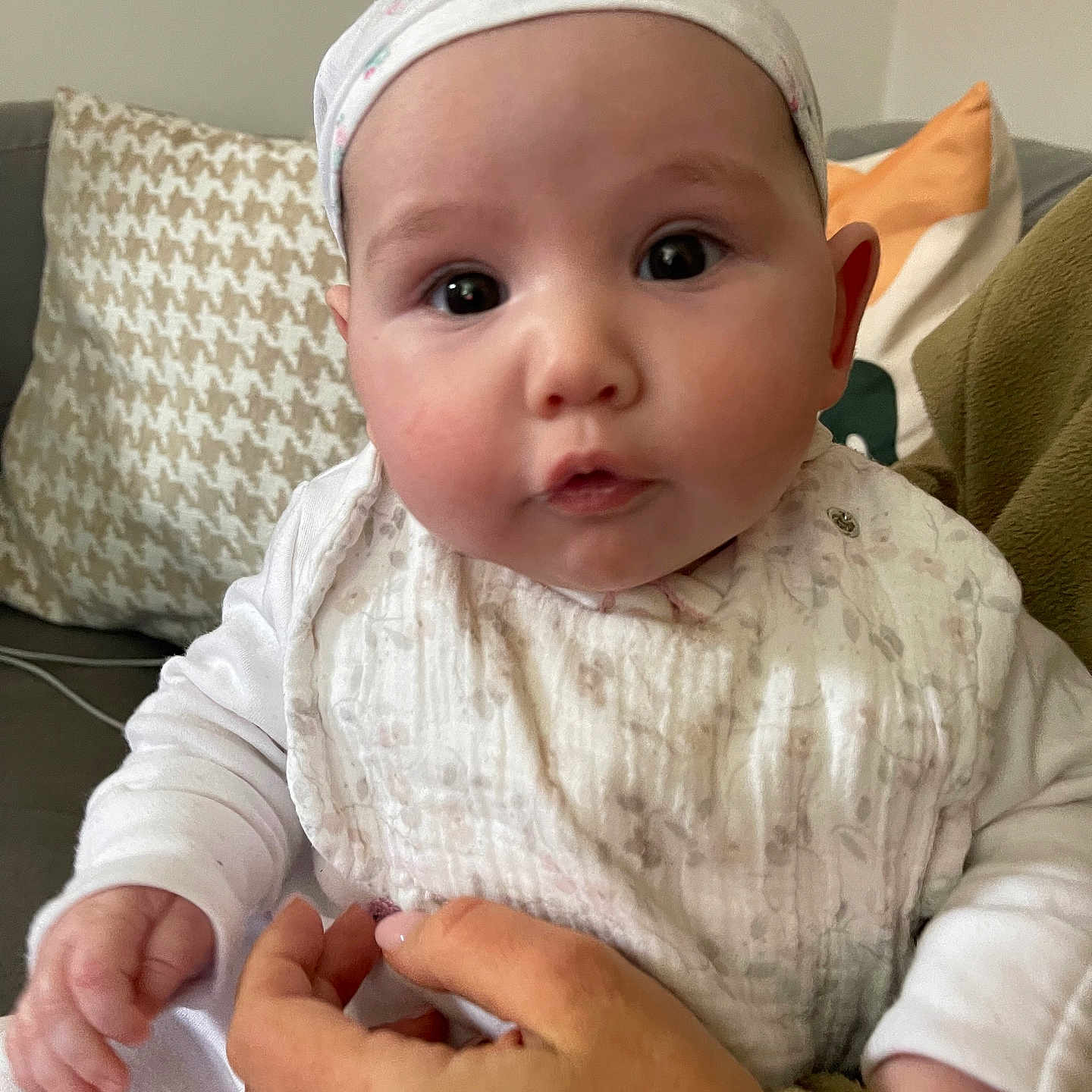 Maia joined the competition — help win amazing prizes! baby, bodypart, bonnet, cap, clothing, couch, cushion, face, finger, furniture, hand, hat, head, homedecor, newborn, pants, person, photography, portrait, sitting