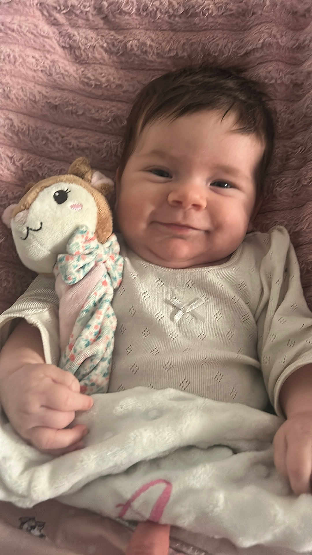 Arya a rejoint le concours — aidez-le/la à gagner de superbes lots ! baby, infant, smile, plush_toy, blanket, onesie, hand, face, cheeks, hair, portrait, close_up, cozy, soft_texture, pillow, bed, happy, nursery, cute, child