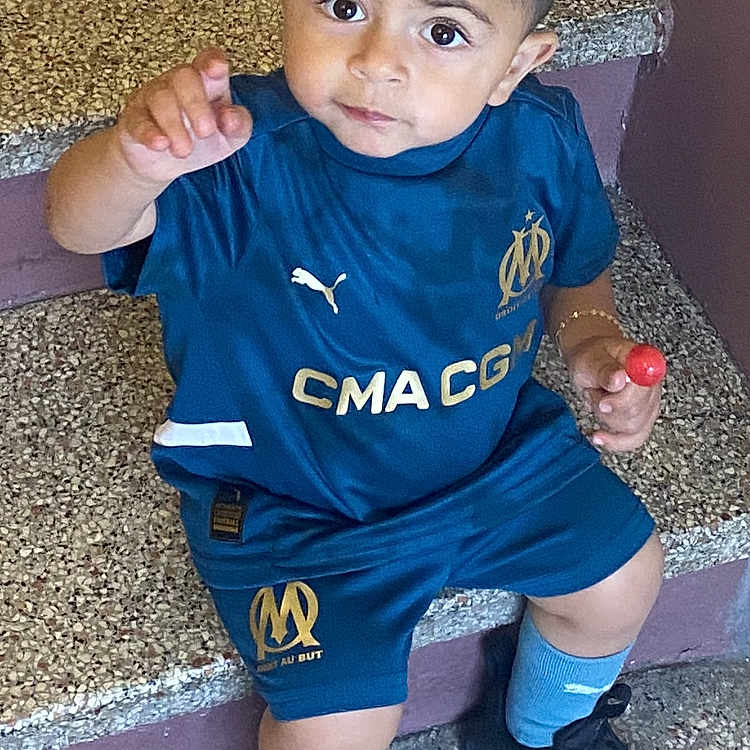Kessim participe au concours pour gagner de l'argent avec cette photo : blue_clothing, casual, child, curious, expression, floor, indoor, lollipop, looking_up, person, pointing, portrait, short_hair, sitting, sneakers, socks, sportswear, stairs, toddler, young_child