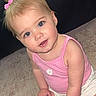 toddler, child, blonde_hair, pink_bows, pink_tank_top, white_shorts, carpet, leather_couch, indoor, cute, sitting, holding_object, curious_expression, blue_eyes, baby, small_hands, floor, package, portrait, young_child