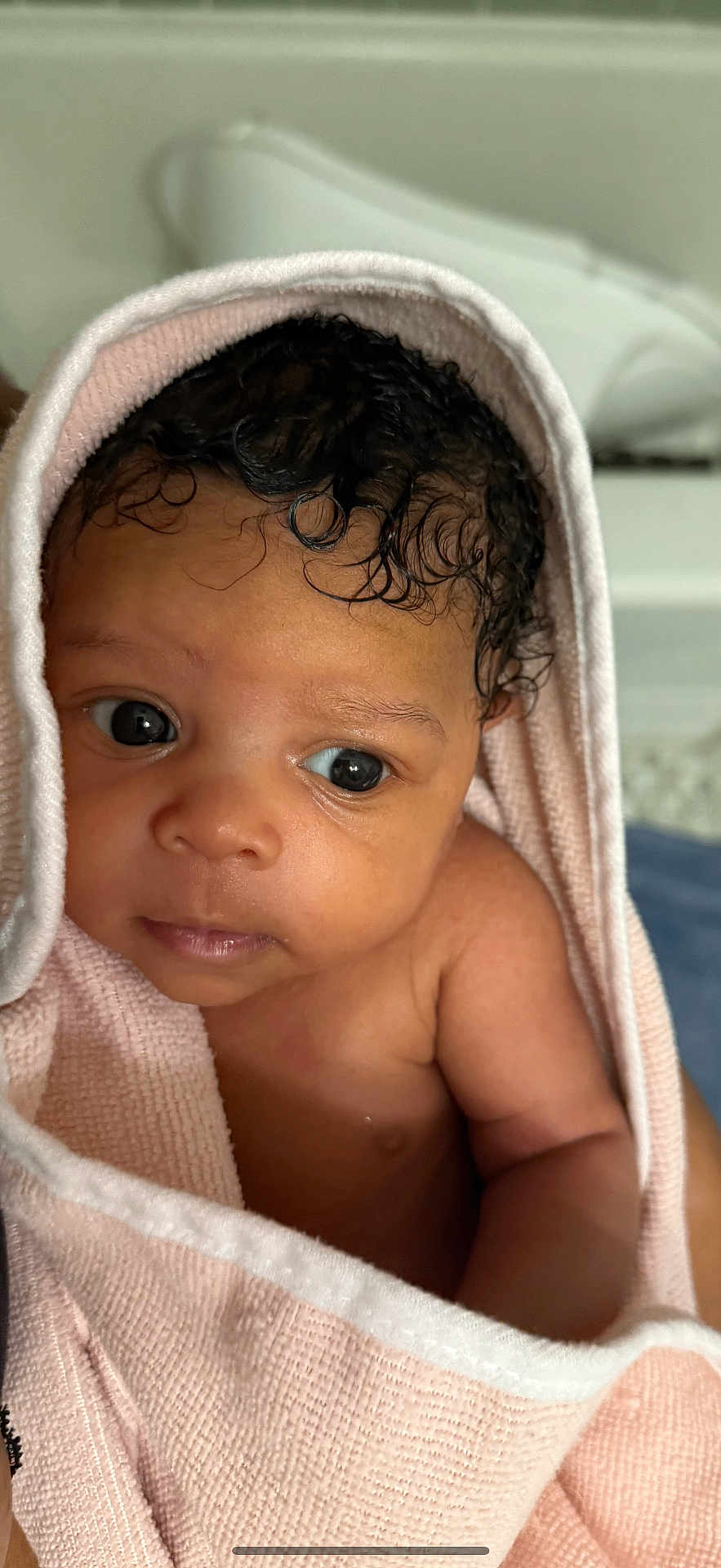 Nylah is registered to the contest to win money with this photo: adorable, baby, child, closeup, curly_hair, cute, expression, eyes, face, human, indoor, infant, newborn, person, pink, portrait, skin, soft_texture, towel, wrapped