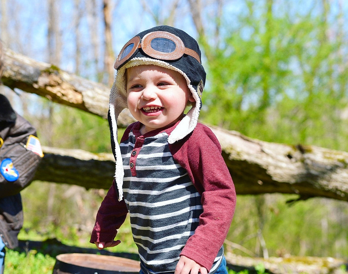 Makai is registered to the contest to win money with this photo: adventure, cap, child, fashion_accessory, forest, fun, grass, happy, headwear, joy, landscape, leisure, membranophone, people_in_nature, person, recreation, sitting, smile, soil, toddler