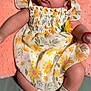 Madison is registered to the contest to win money with this photo: baby, child, infant, dress, floral_pattern, socks, cushion, soft_texture, cute, face, eyes, skin, hair, sitting, indoors, pink, yellow, white, green, adorable