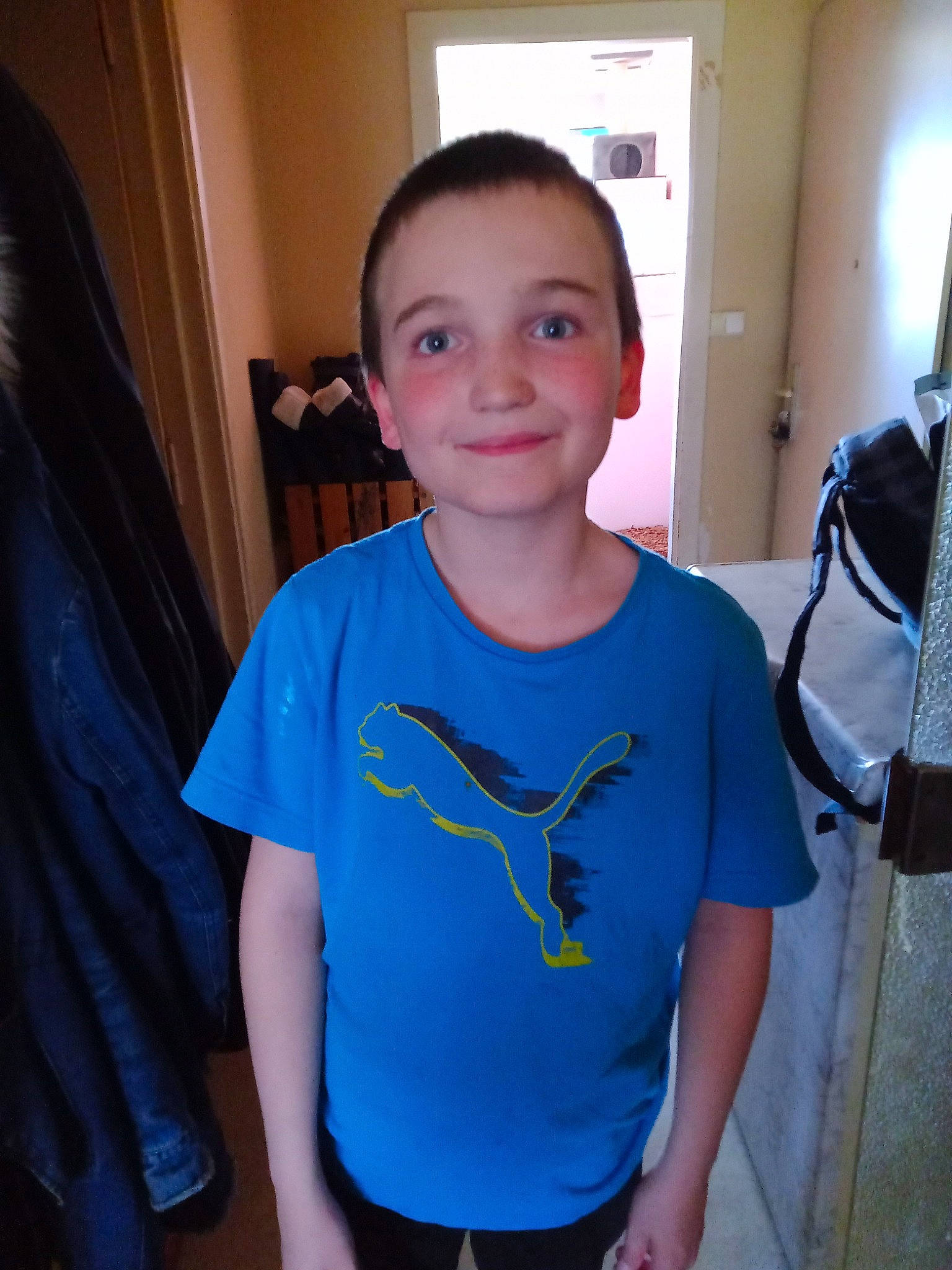 Esteban participe au concours pour gagner de l'argent avec cette photo : active_shirt, chest, child, chin, curtain, electric_blue, forehead, fun, hairstyle, happy, joint, joy, neck, person, shoulder, skin, sleeve, smile, standing, t_shirt