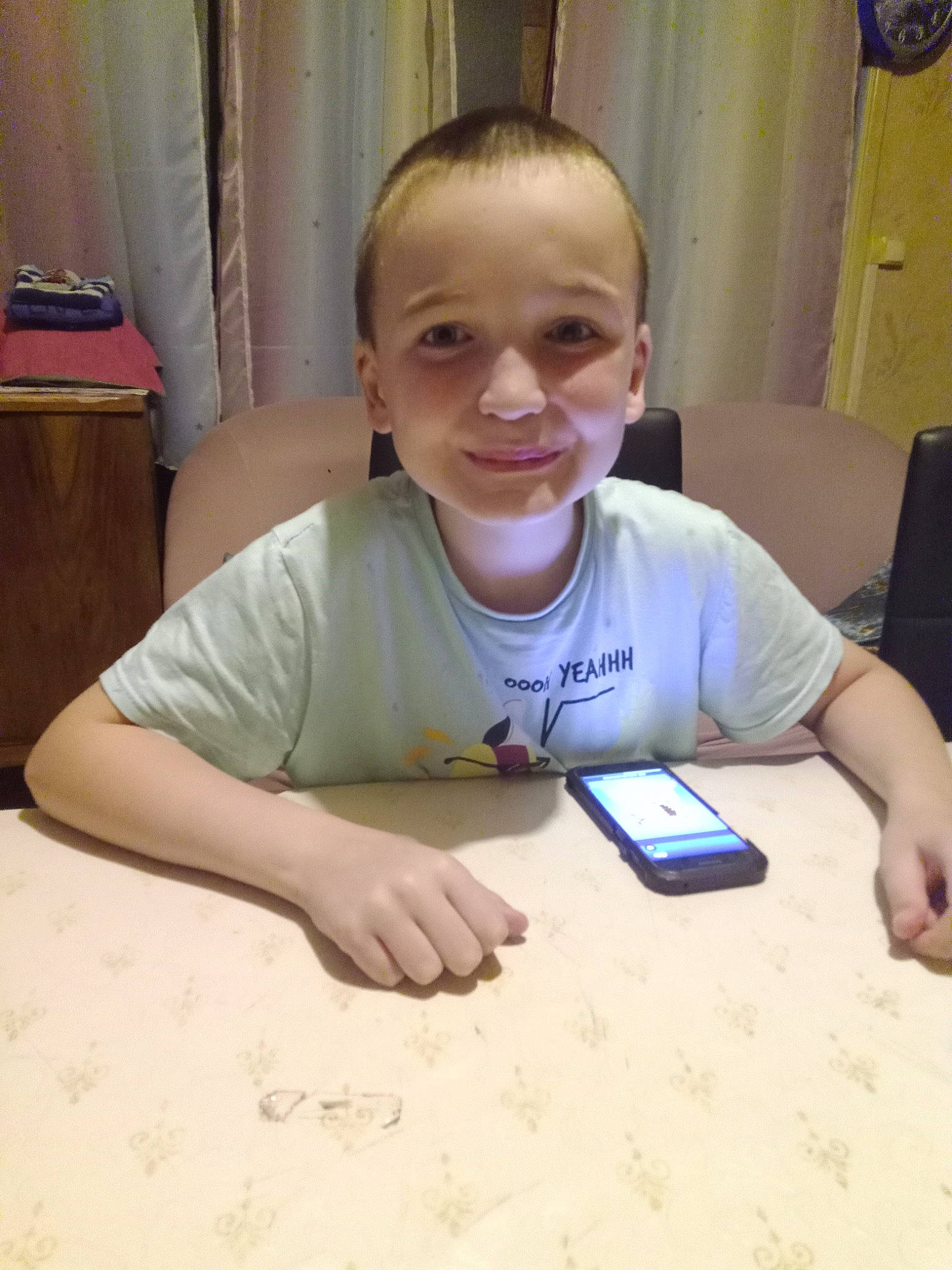 Esteban participe au concours pour gagner de l'argent avec cette photo : communication_device, curtain, flooring, fun, gadget, indoor_games_and_sports, joy, mobile_phone, nail, person, play, puzzle, recreation, room, sharing, sitting, smile, t_shirt, table, thumb