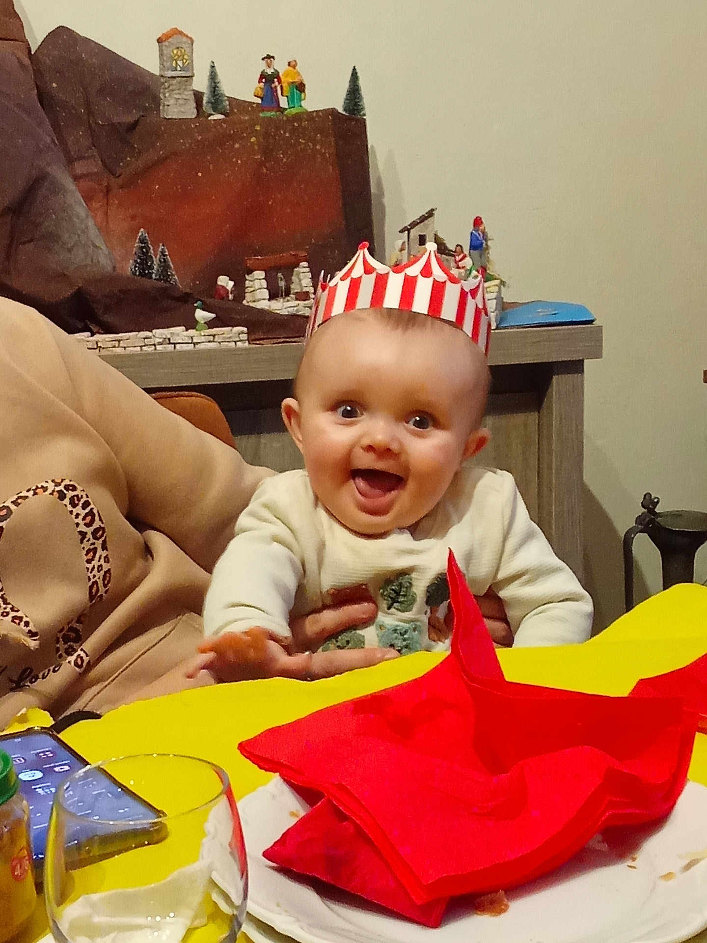 Leo participe au concours pour gagner de l'argent avec cette photo : baby, child, crown, table, napkin, red, yellow, plate, glass, person, hand, clothing, decor, toy, miniature, smile, happy, indoor, celebration, family