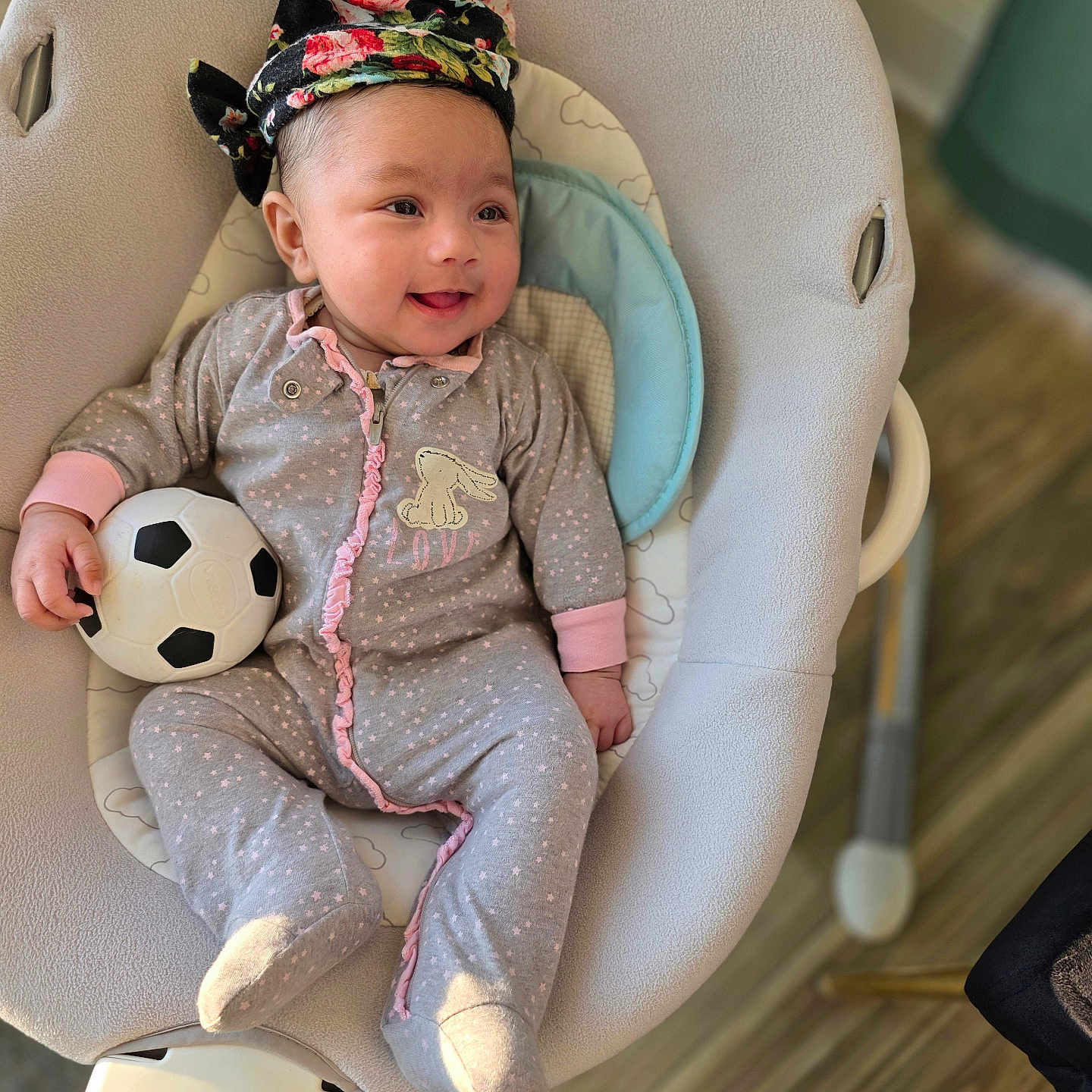 Vedanya Aruna Jain is registered to the contest to win money with this photo: baby, baby_rocker, child, cozy, cute, face, flooring, grey_clothing, happy, headwrap, indoor, infant, onesie, person, pink, playful, smiling, soccer_ball, toy, wood_floor