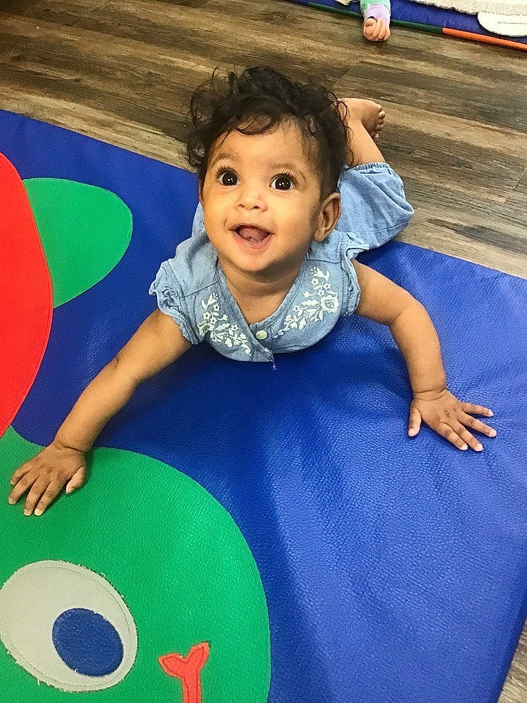 Amira is registered to the contest to win money with this photo: baby, baby_playing_with_toys, baby_toddler_clothing, ball, blue, child, circle, electric_blue, flooring, fun, happy, leisure, magenta, person, play, purple, recreation, sitting, smile, t_shirt