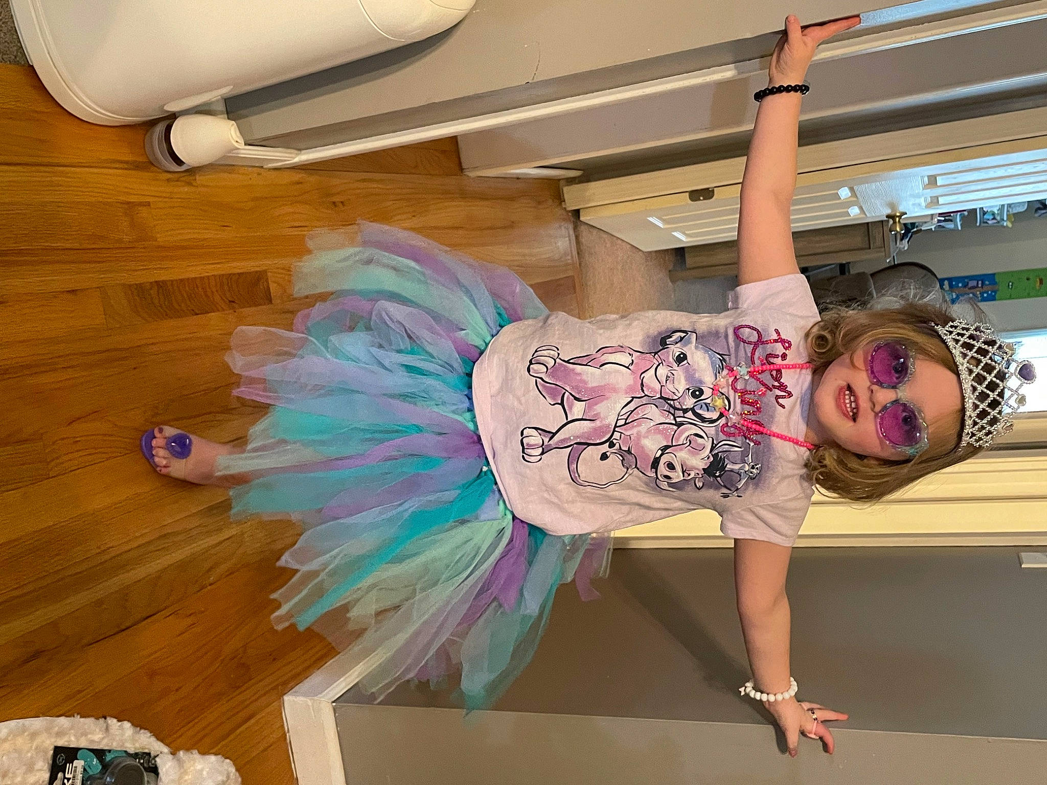 Brooke is registered to the contest to win money with this photo: ceiling, child, fashion_design, floor, flooring, fun, happy, hardwood, headwear, human_leg, leisure, magenta, mechanical_fan, mythical_creature, person, pink, room, sandal, t_shirt, thigh
