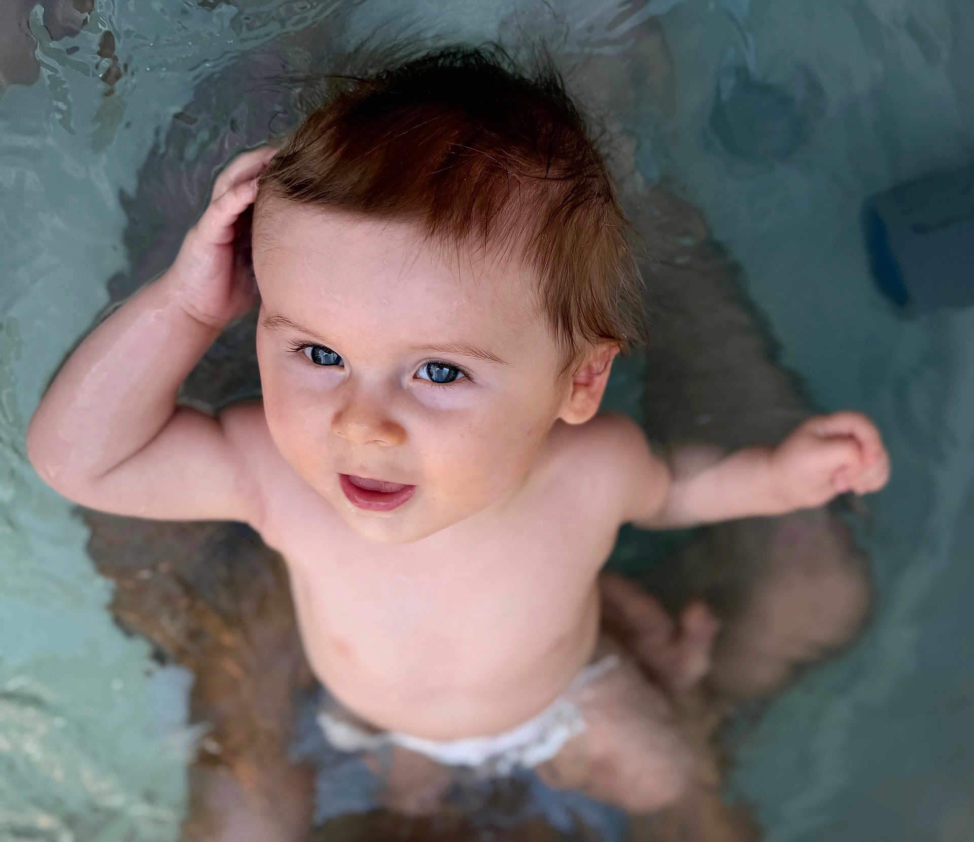 Rafaël participe au concours pour gagner de l'argent avec cette photo : baby, water, blue_eyes, diaper, child, skin, arm, hand, face, head, splash, swimming, pool, playful, cute, infant, young_child, wet_hair, bath_time, portrait