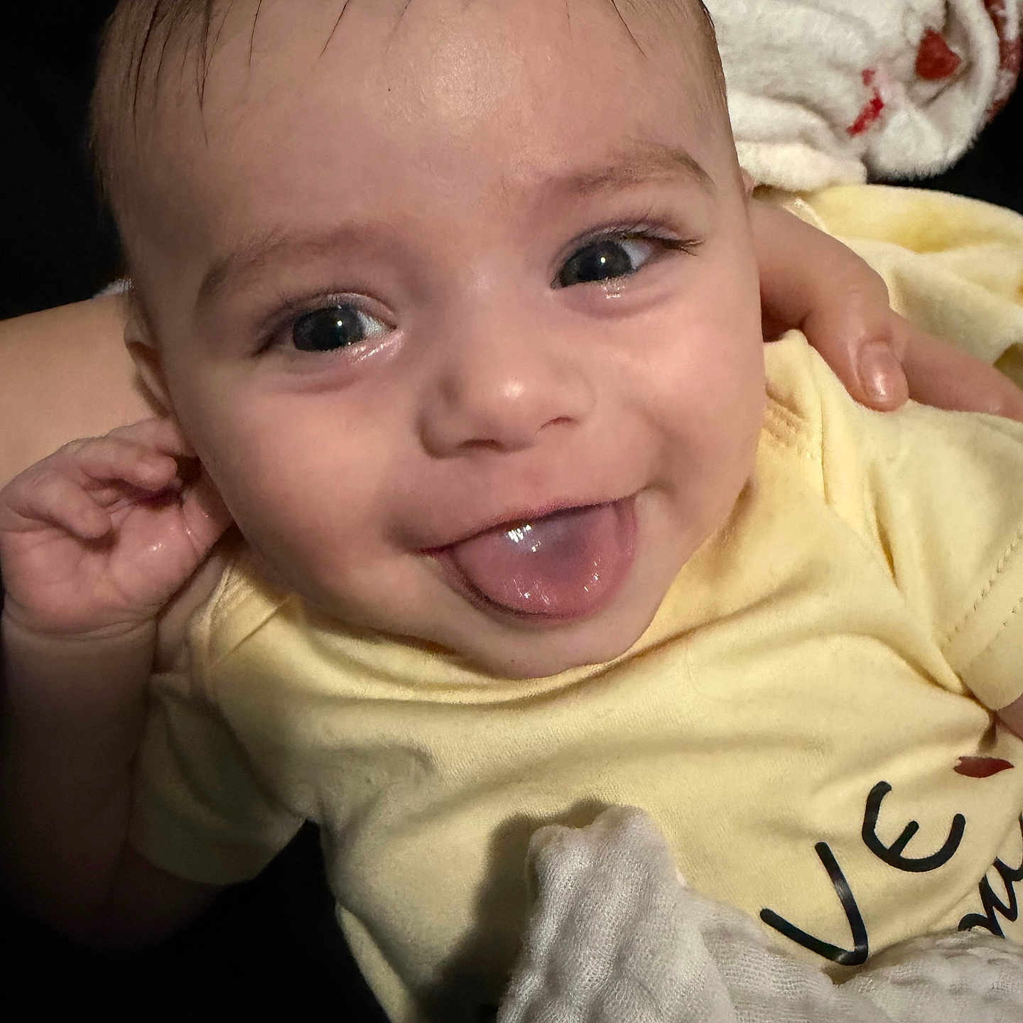 Hunter joined the competition — help win amazing prizes! baby, blanket, close_up, cute, eyelashes, eyes, face, hair, hand, happy, indoor, infant, onesie, parent_hand, portrait, skin, smiling, soft_texture, tongue_out, yellow_clothing
