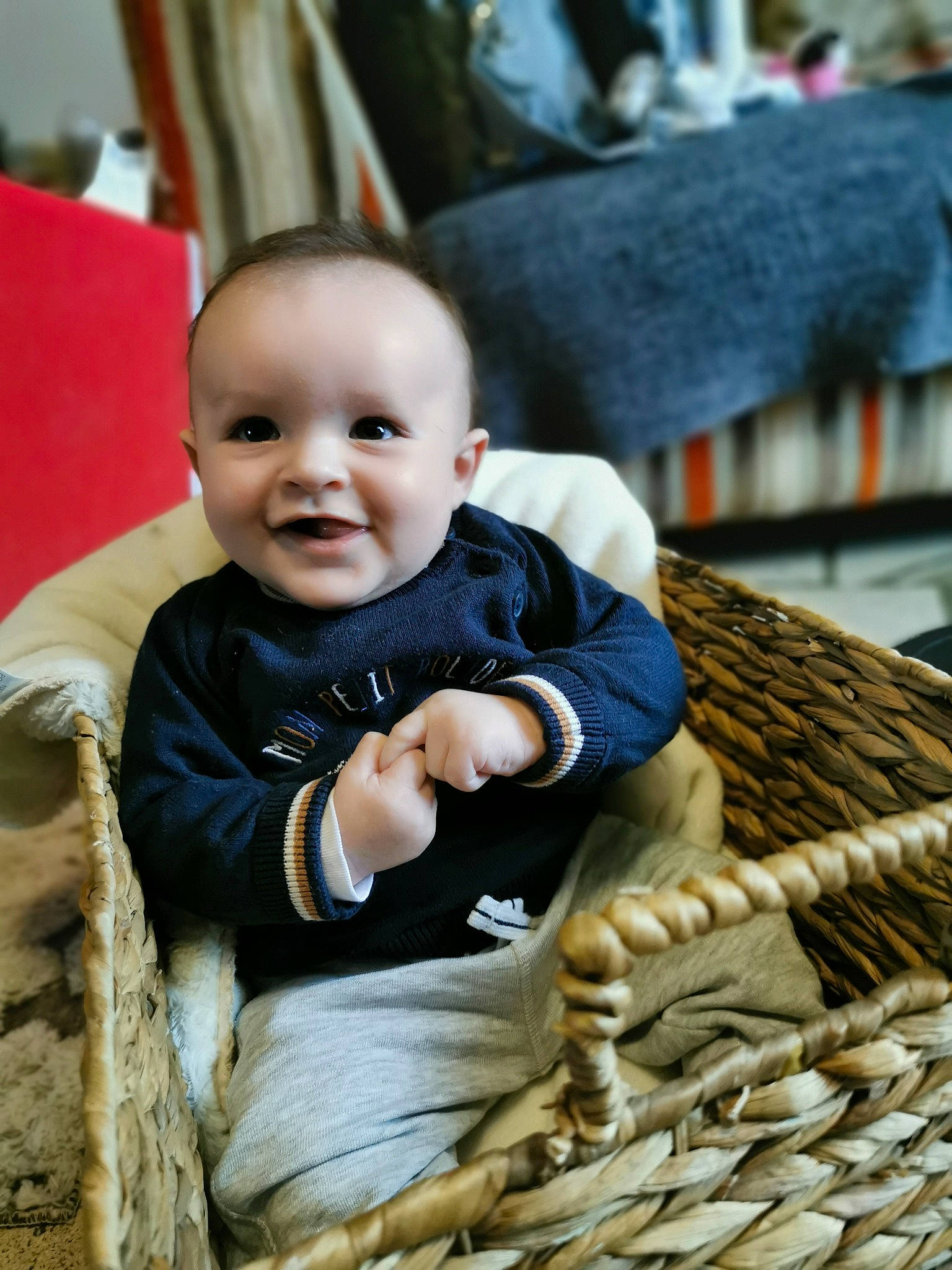 Batiste a rejoint le concours — aidez-le/la à gagner de superbes lots ! baby, baby_toddler_clothing, basket, cheek, child, comfort, eye, flooring, fun, grass, happy, joy, person, sitting, skin, sleeve, smile, storage_basket, t_shirt, toddler