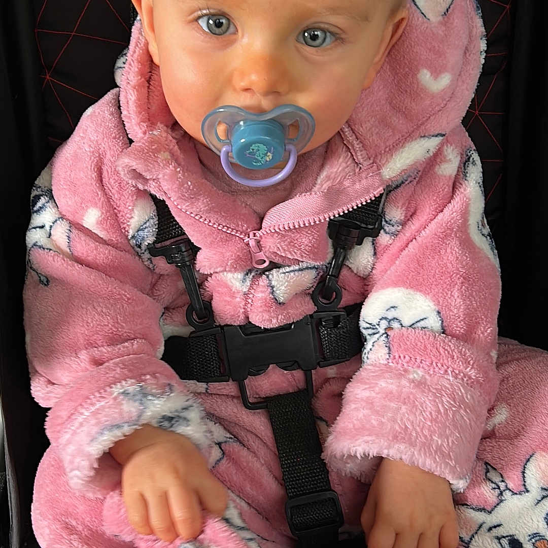 Dorya Leprout participe au concours pour gagner de l'argent avec cette photo : baby, baby_clothes, blue_eyes, bunny_prints, car_seat, child, close_up, clothing, cute, face, hand, indoor, infant, pacifier, pink_onesie, portrait, safety, seatbelt, sitting, young_child