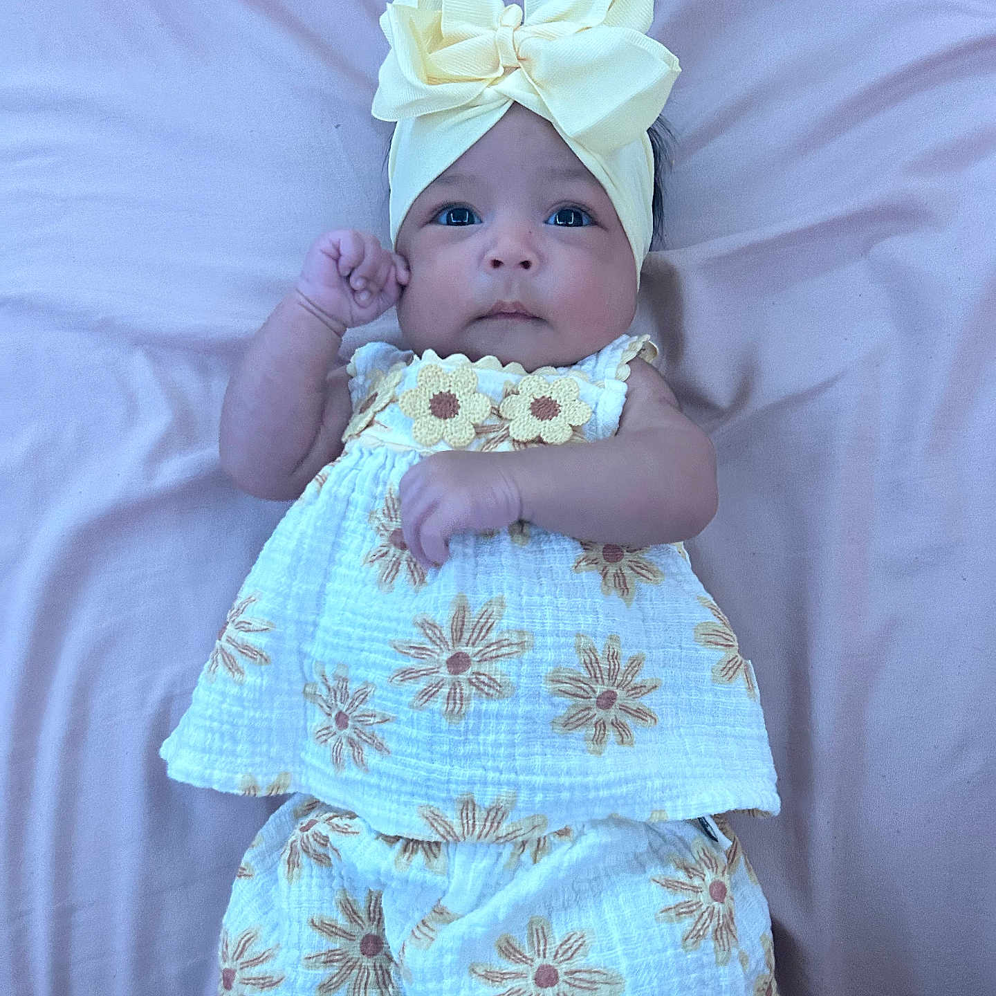 Nova joined the competition — help win amazing prizes! baby, infant, child, headband, bow, flower_pattern, clothing, blanket, pink_background, cute, portrait, lying_down, fist, young_child, soft_texture, sleepwear, adorable, face, person, newborn