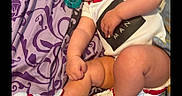 Jose Luis joined the competition — help win amazing prizes! baby, blanket, child, chubby, clothing, cute, footwear, hand, head, indoor, infant, laying_down, leg, onesie, pacifier, pattern, person, purple, skin, sneakers