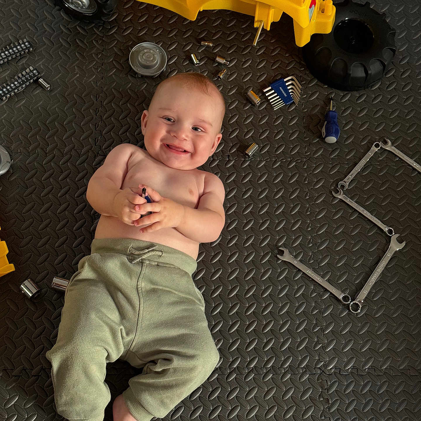 Yaroslav participe au concours pour gagner de l'argent avec cette photo : allen_keys, baby, bare_chest, child, clothing, face, floor_mat, foot, hand, happy, indoor, infant, pants, playtime, screwdriver, smile, tools, toy, wrenches, yellow_toy