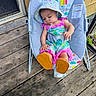 baby, infant, child, sleeping, baby_rocker, hat, colorful_clothing, outdoor, wooden_deck, footwear, sun_hat, baby_seat, peaceful, toddler, cartoon_design, rainbow, monkey, relaxing, summer, cute