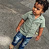 Jordan is registered to the contest to win money with this photo: child, toddler, curly_hair, green_shirt, blue_jeans, sandals, sidewalk, outdoor, pavement, standing, casual_clothing, young_child, person, street, curious, portrait, daylight, cute, fashion, kid
