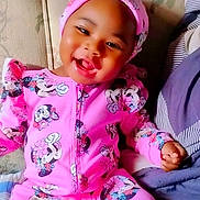E'Mani is registered to the contest to win money with this photo: toddler, child, smiling, pink_clothing, minnie_mouse, headwear, sitting, couch, floral_pattern, happy, indoors, portrait, baby, cute, young_child, cozy, bright_colors, playful, fashion, person