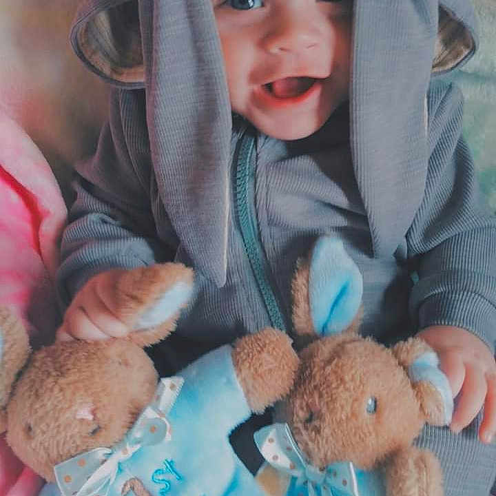 Milo joined the competition — help win amazing prizes! baby, babylaughing, blanket, clothing, coat, face, happy, hat, head, hood, hoodie, knitwear, person, photography, portrait, smile, sweater, sweatshirt, teddybear, toy