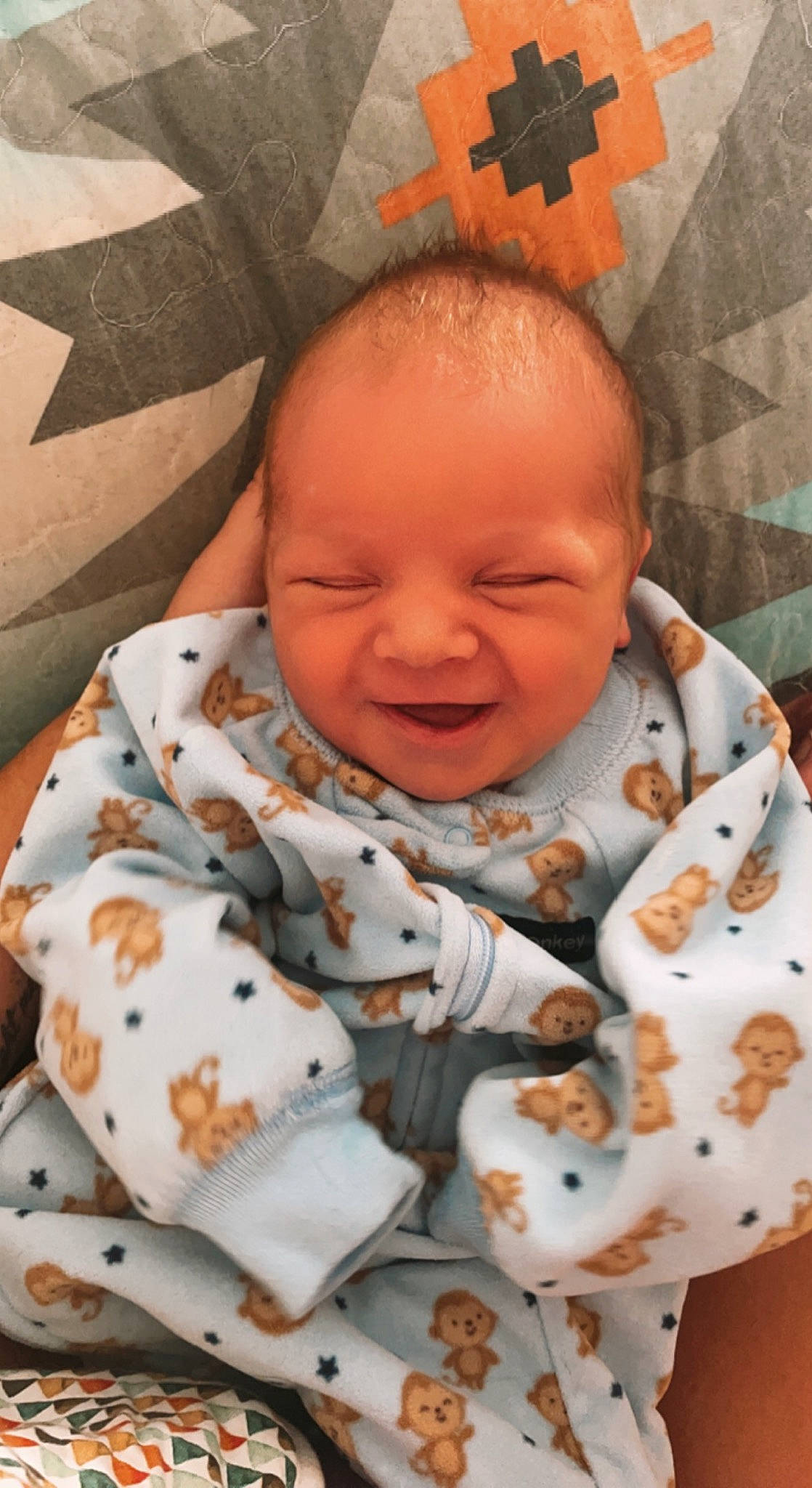 Gannon is registered to the contest to win money with this photo: baby, baby_toddler_clothing, cheek, chin, collar, comfort, face, facial_expression, head, nose, orange, outerwear, people, person, product, skin, sleeve, smile, textile, toddler