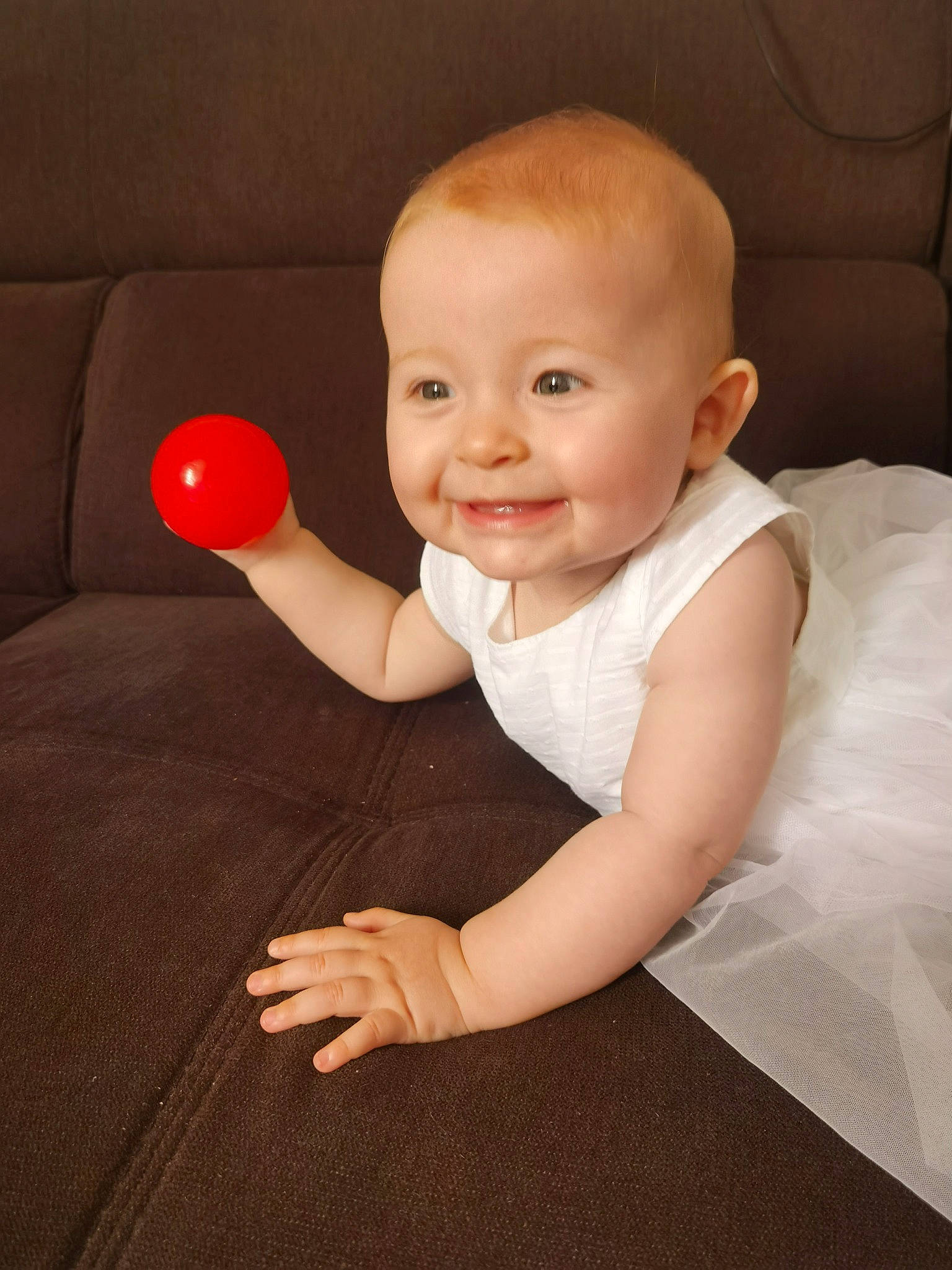 Mya participe au concours pour gagner de l'argent avec cette photo : arm, baby, baby_toddler_clothing, cheek, chin, comfort, dress, facial_expression, finger, flash_photography, flooring, gesture, hairstyle, hand, human_body, joy, person, pink, skin, sleeve