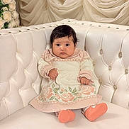 Faith is registered to the contest to win money with this photo: baby, infant, child, cute, sitting, knit_dress, floral_pattern, booties, white_couch, tufted_couch, soft_lighting, indoor, portrait, curly_hair, plush, decor, flowers, elegant, cozy, adorable