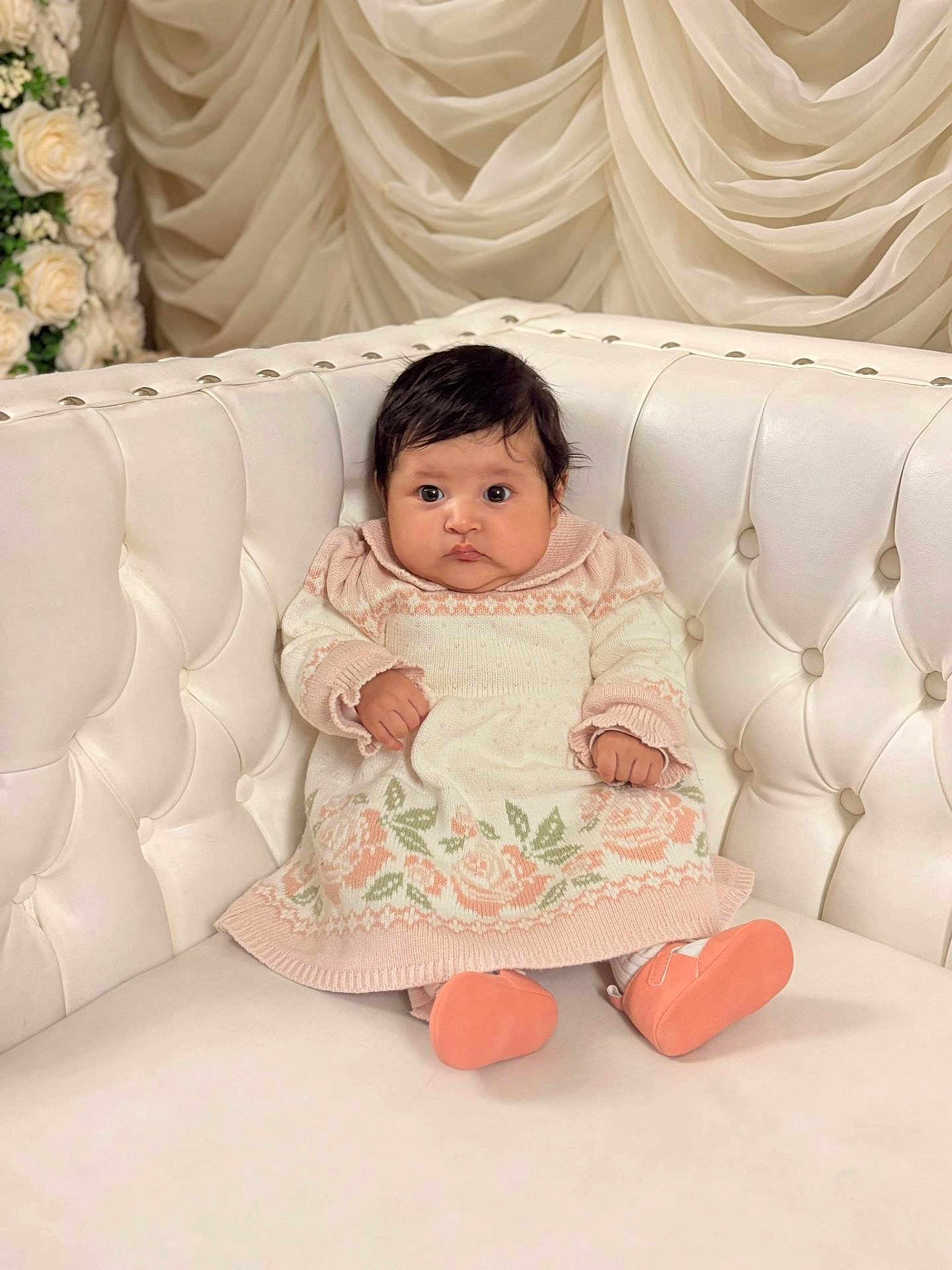 Faith is registered to the contest to win money with this photo: baby, infant, child, cute, sitting, knit_dress, floral_pattern, booties, white_couch, tufted_couch, soft_lighting, indoor, portrait, curly_hair, plush, decor, flowers, elegant, cozy, adorable