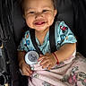 Keyri is registered to the contest to win money with this photo: baby, baby_toy, blanket, blue, bottle, child, clothing, cute, face, hand, happy, indoor, infant, mickey_mouse, person, pink, portrait, seatbelt, smiling, stroller