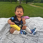 Keyri joined the competition — help win amazing prizes! baby, banana, blanket, child, cute, grass, greenery, happy, jersey, outdoor, park, person, phone, play, sitting, smiling, sneakers, socks, toy, tree