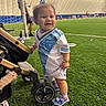 Keyri is registered to the contest to win money with this photo: blurred_background, child, coach, goal_net, grass, hat, indoor_field, jersey, lights, person, playing_field, recreation, shoes, smiling, soccer, socks, sports, stroller, team, toddler