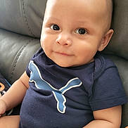 Ruben joined the competition — help win amazing prizes! baby, infant, smiling, onesie, blue_clothing, puma_logo, couch, leather_furniture, indoor, cute, child, portrait, sitting, chubby_cheeks, short_hair, skin, hand, arm, face, happy