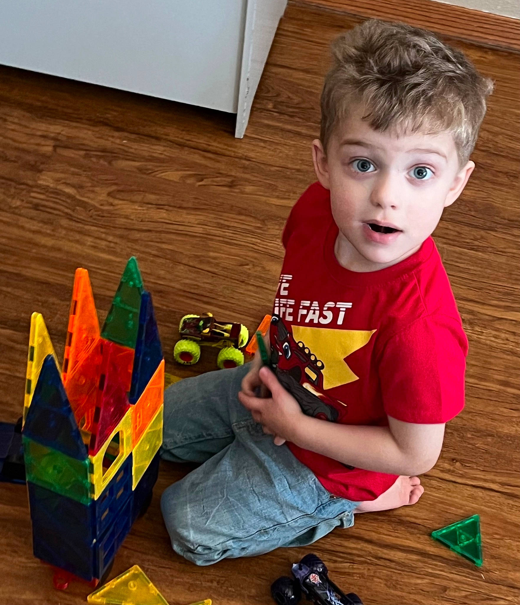 Joshua is registered to the contest to win money with this photo: child, craft, creative_arts, flooring, fun, happy, hardwood, holiday, person, plastic, play, room, sharing, sitting, sleeve, surprise, t_shirt, toddler, toy, triangle