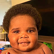 Saif is registered to the contest to win money with this photo: baby, child, infant, portrait, face, smiling, eyes, curly_hair, indoor, home, close_up, happy, curious, skin, drool, head, shoulders, warm_lighting, photography, person